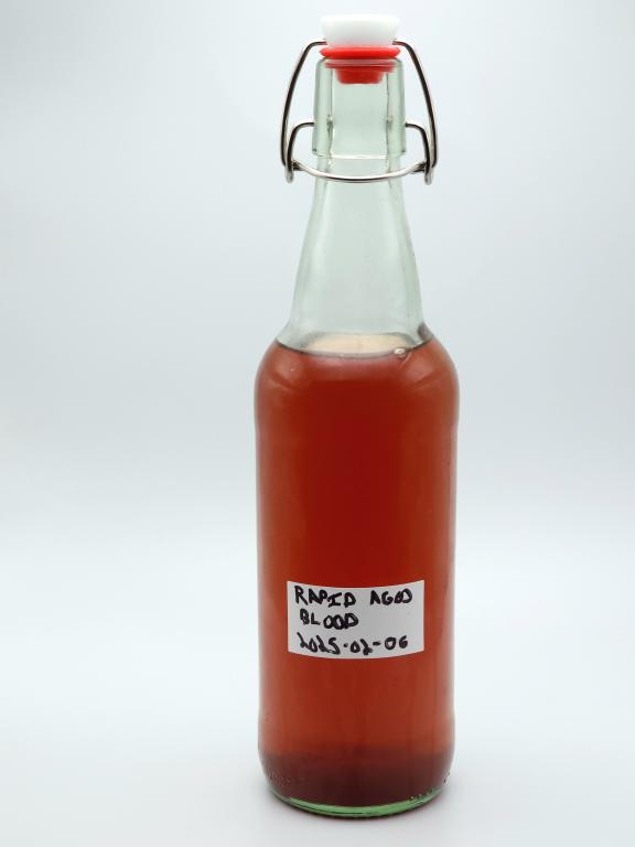 A swing-top bottle of reddish liquid labeled "Rapid Aged Blood"